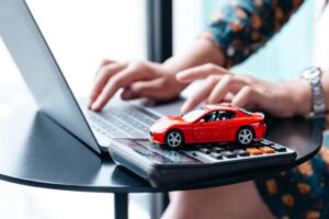 auto in miniatura con una calcolatrice e un computer