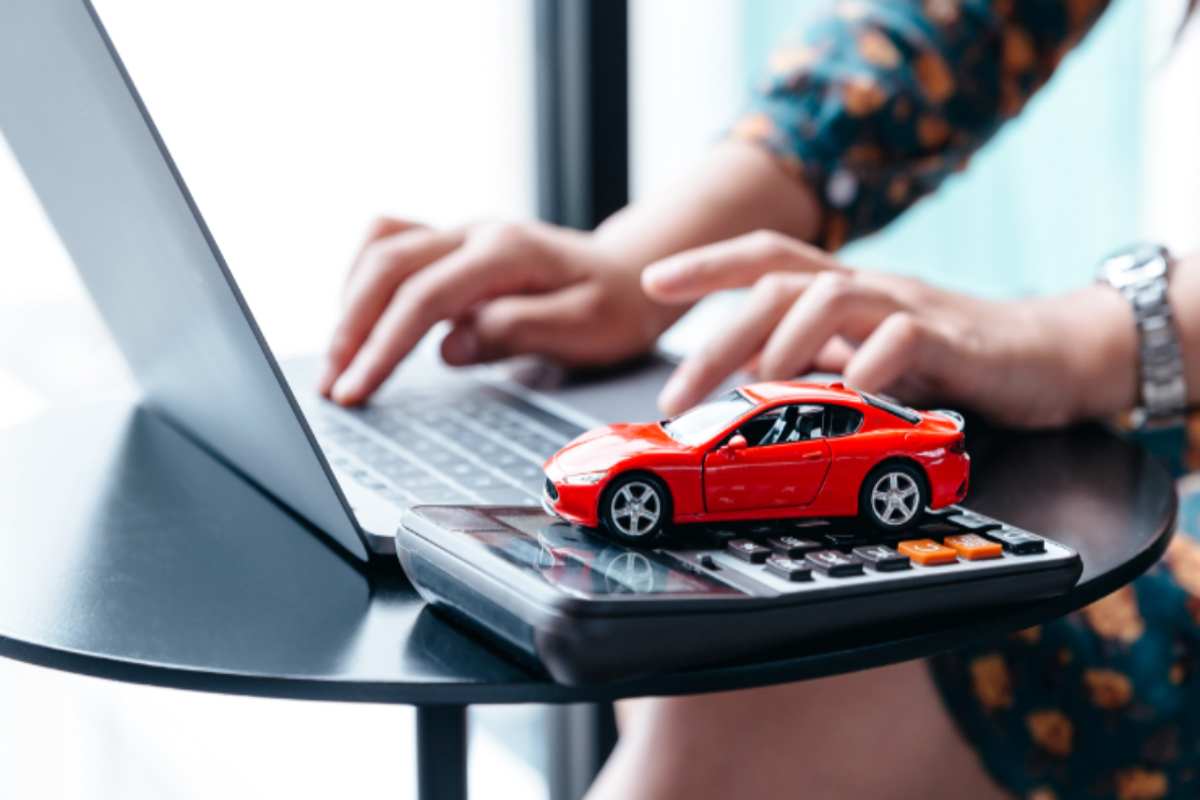 auto in miniatura con una calcolatrice e un computer